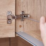 Problem z niesprawnymi zawiasami w szafce pod umywalką – regulacja i wymiana okuć